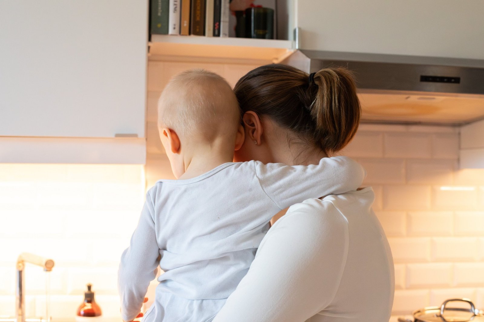 Photo, mother holding her baby in the kitchen